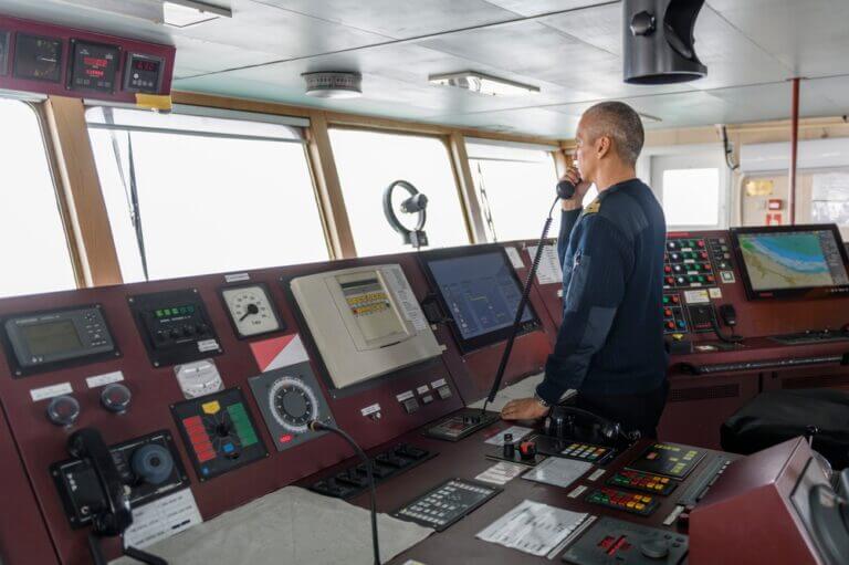 Officer,On,Watch,With,Radio,On,The,Navigational,Bridge.,Caucasian
