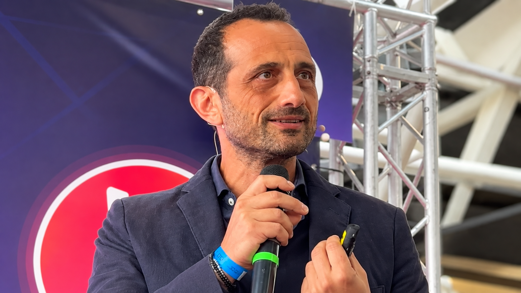 Relatore sul palco con microfono e truss
